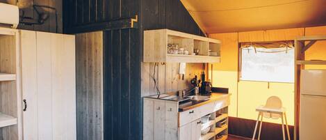 A compact kitchen with wooden cabinets, a small countertop, and a refrigerator.