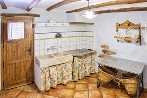 A rustic kitchen with wooden beams, a double sink, and a hanging dish rack. - 6-Guest Holiday Home in Central Laroya (Laroya)