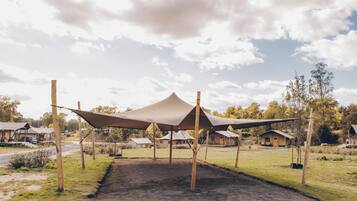 A campsite with multiple tents and a dirt ground.
