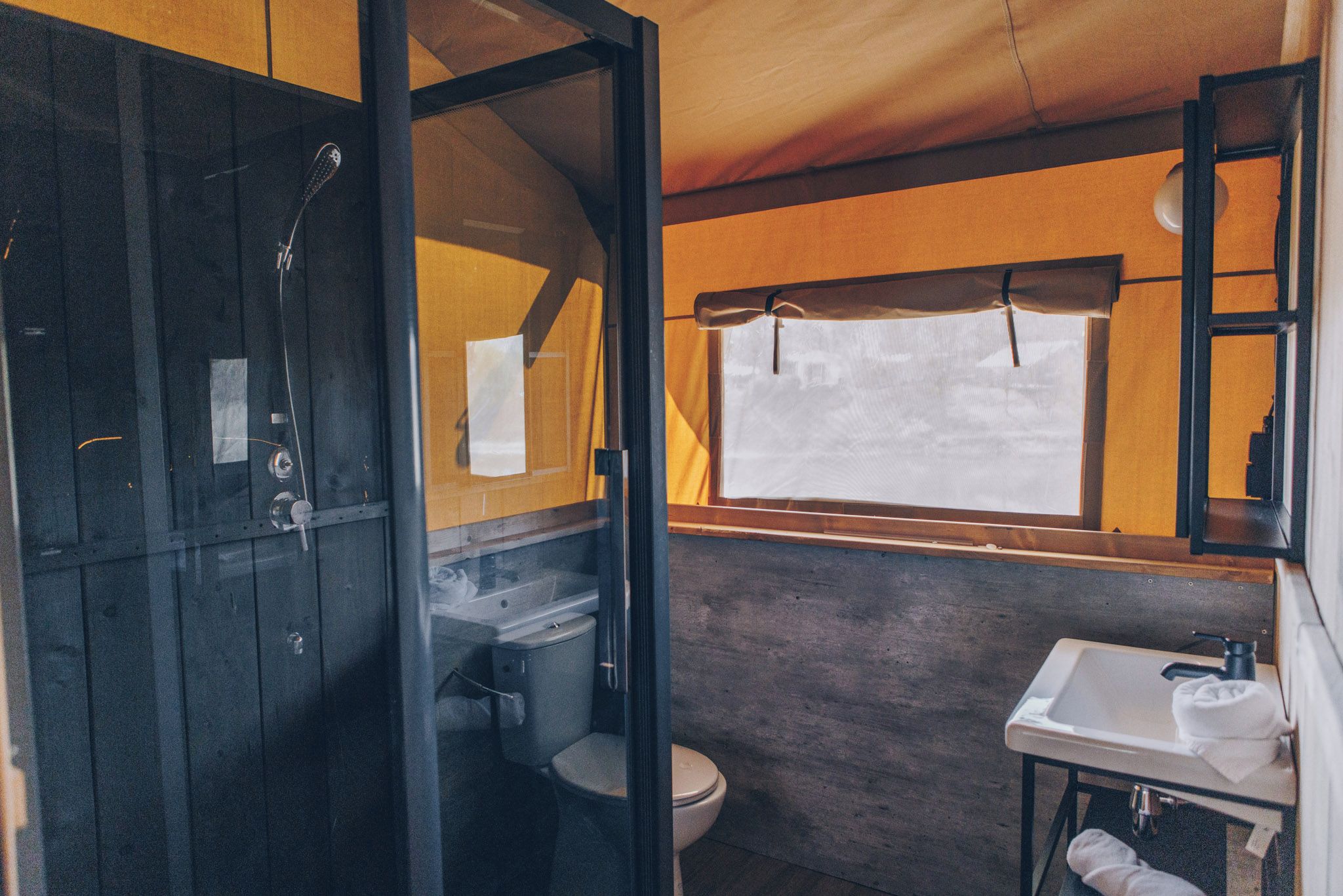 Ein kleines, abgeschlossenes Badezimmer mit Dusche, Toilette und Waschbecken.