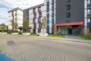 A modern multi-story building with a flat roof, large windows, and a ground-level entrance. - Cracow | Łaszkiewicza 8B | Comfortable Apartment | Parking (Kraków)