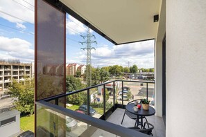 A balcony with a view of a parking lot and buildings. - Cracow | Łaszkiewicza 8B | Comfortable Apartment | Parking (Kraków)