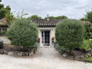 A house with a tiled roof, a stone wall, and a gravel pathway leading to a door. - Holiday Home 'Sautou' with Private Pool, Private Terrace and Wi-Fi (Penne-d'Agenais)