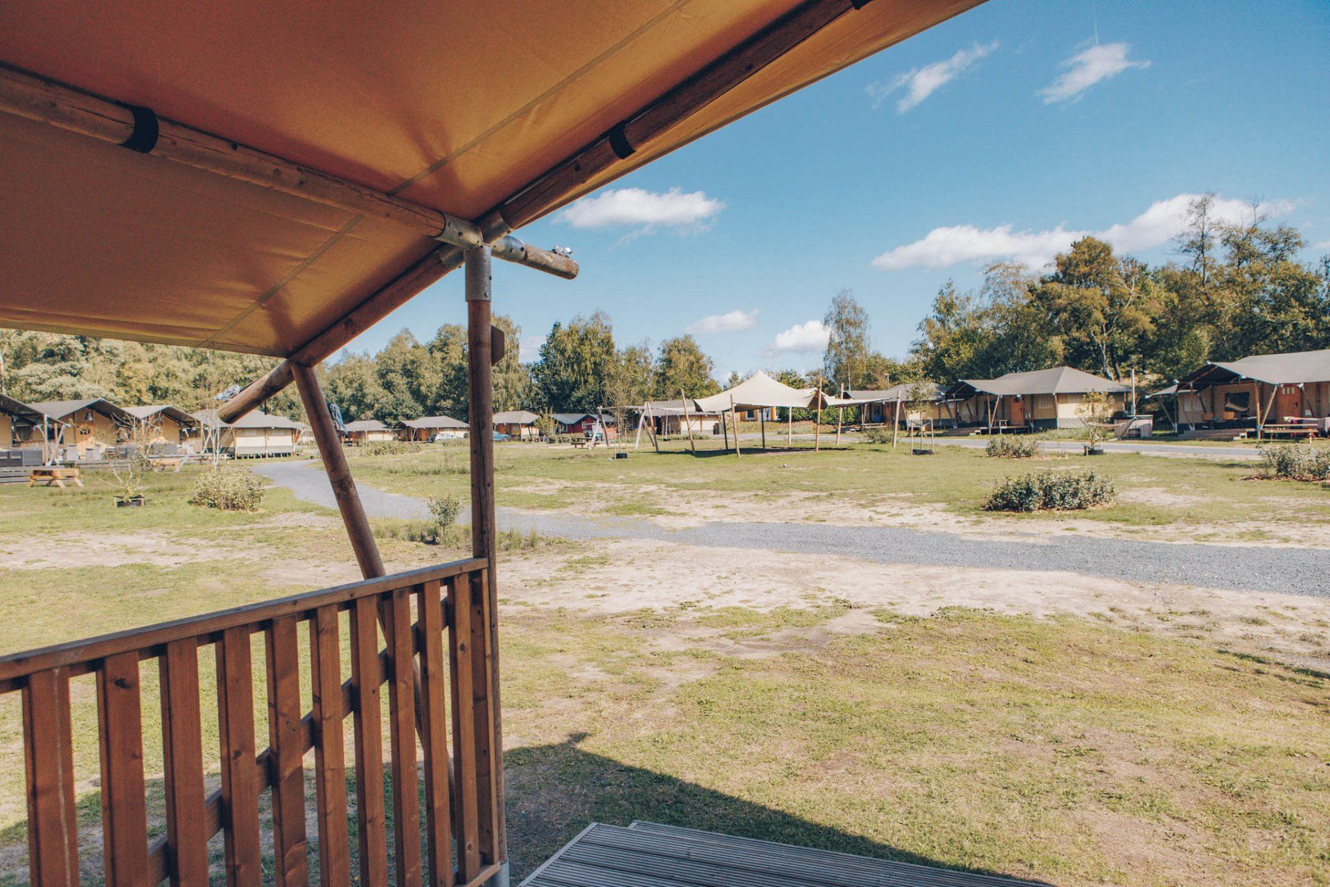 Ein Campingplatz mit mehreren Hütten, einem überdachten Picknickbereich und einem Rasenfeld.