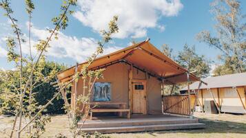 A wooden cabin with a porch and a covered entrance.