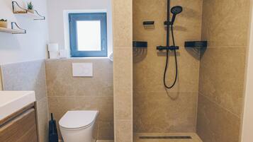 Ein Badezimmer mit Toilette, Dusche und Fenster.
