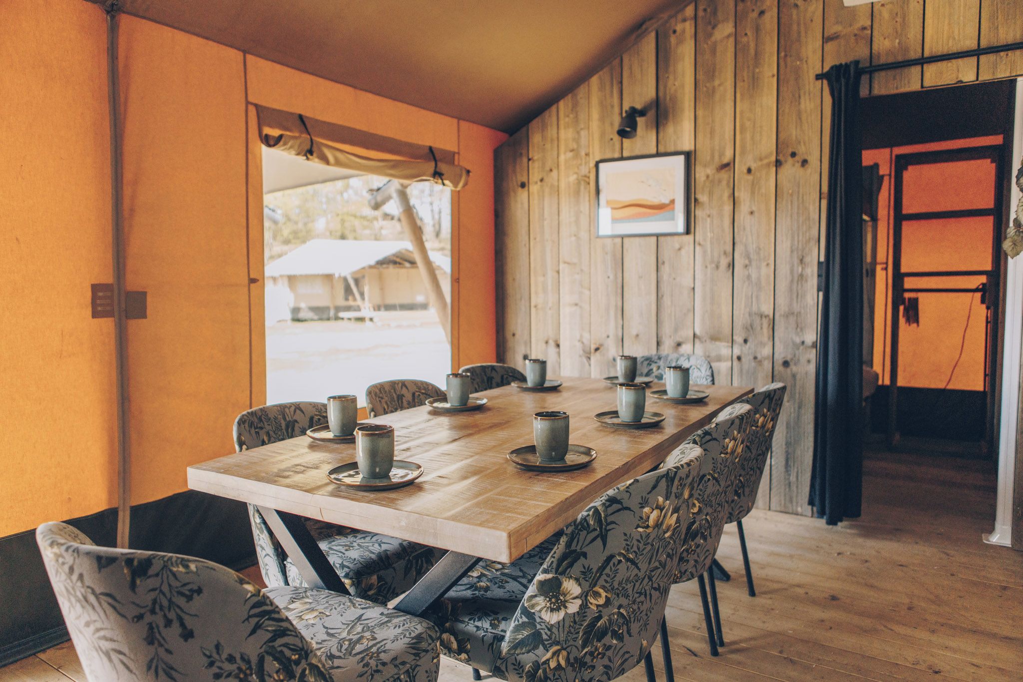 Ein Esstisch aus Holz mit Stühlen, gedeckt für eine Mahlzeit.