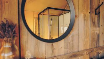 Un intérieur en bois avec un miroir rond qui reflète une pièce.