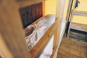 Una cama litera con cabecera de madera y colchón blanco.