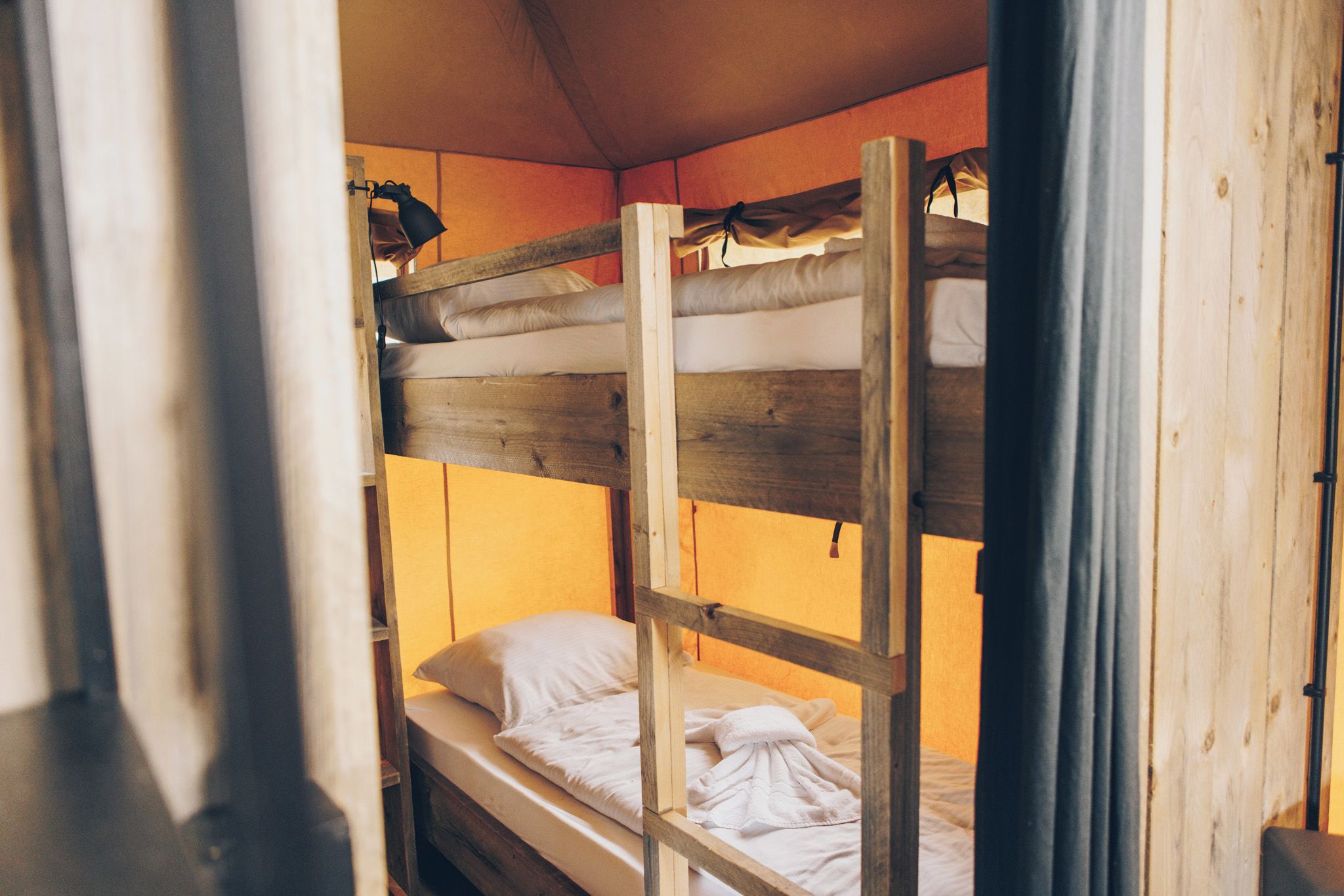 Un lit superposé avec une structure en bois et un matelas.