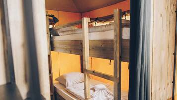 Un lit superposé avec une structure en bois et un matelas.