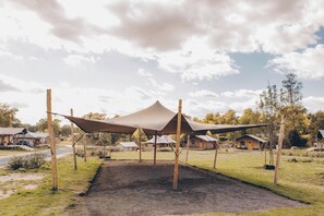 Een camping met meerdere tenten en een onverharde ondergrond.