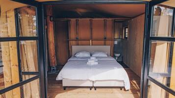 Ein Bett mit Kopfteil, Nachttisch und Fenster.
