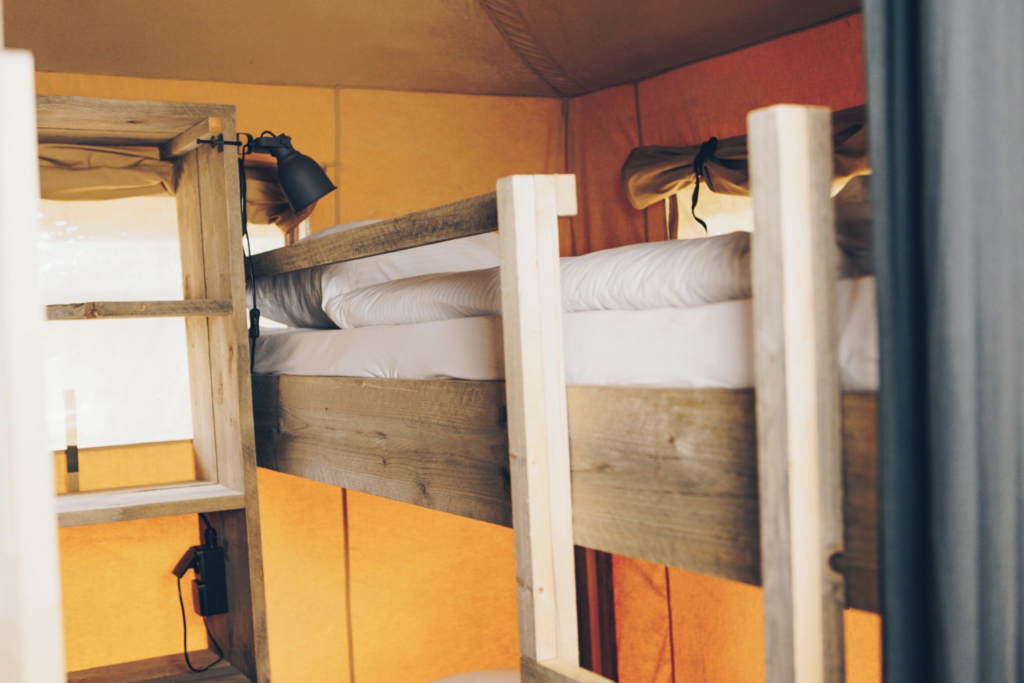 Un letto a castello con struttura in legno e biancheria bianca.