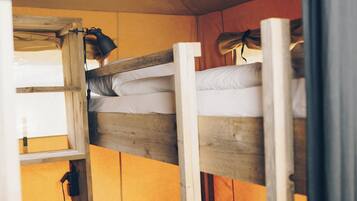 Un letto a castello con struttura in legno e biancheria bianca.