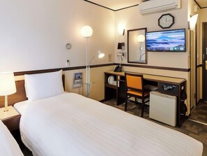 A hotel room with a bed, desk, chair, and a small refrigerator. - Toyoko Inn Kashiwa-eki Nishi-guchi (Kashiwa)