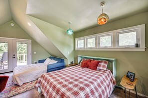 Ein Schlafzimmer mit Schlafgalerie, einem Einzelbett, einem Fenster mit Blick und einer Deckenleuchte.