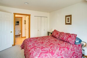 A bedroom with a bed, a door leading to a bathroom, and a framed picture on the wall. - Walk to Yellowstone River! Emigrant Home w/ Patio (Emigrant)