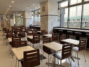 A cafeteria with multiple tables and chairs, a clock on the wall, and large windows. - Toyoko Inn Kitakami Eki Shinkansen Guchi (Kitakami)