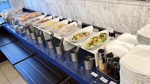 A buffet setup with various food options and serving utensils. - Toyoko Inn Kitakami Eki Shinkansen Guchi (Kitakami)