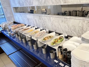A buffet setup with various food options and serving utensils. - Toyoko Inn Kitakami Eki Shinkansen Guchi (Kitakami)