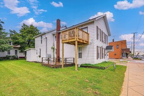 A two-story house with a wooden deck and a brick chimney.