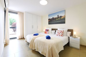 A hotel room with two beds, a painting on the wall, and a view of the outdoors through the window. - Beautiful house at Salobre Golf Resort with private pool (San Bartolomé de Tirajana)