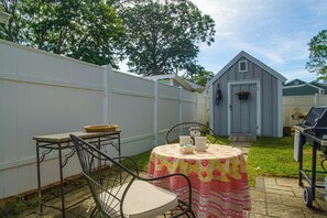 A backyard with a round table, chairs, a barbecue grill, and a shed. - Walk to Beach! Wareham Getaway w/ Patio (Wareham)