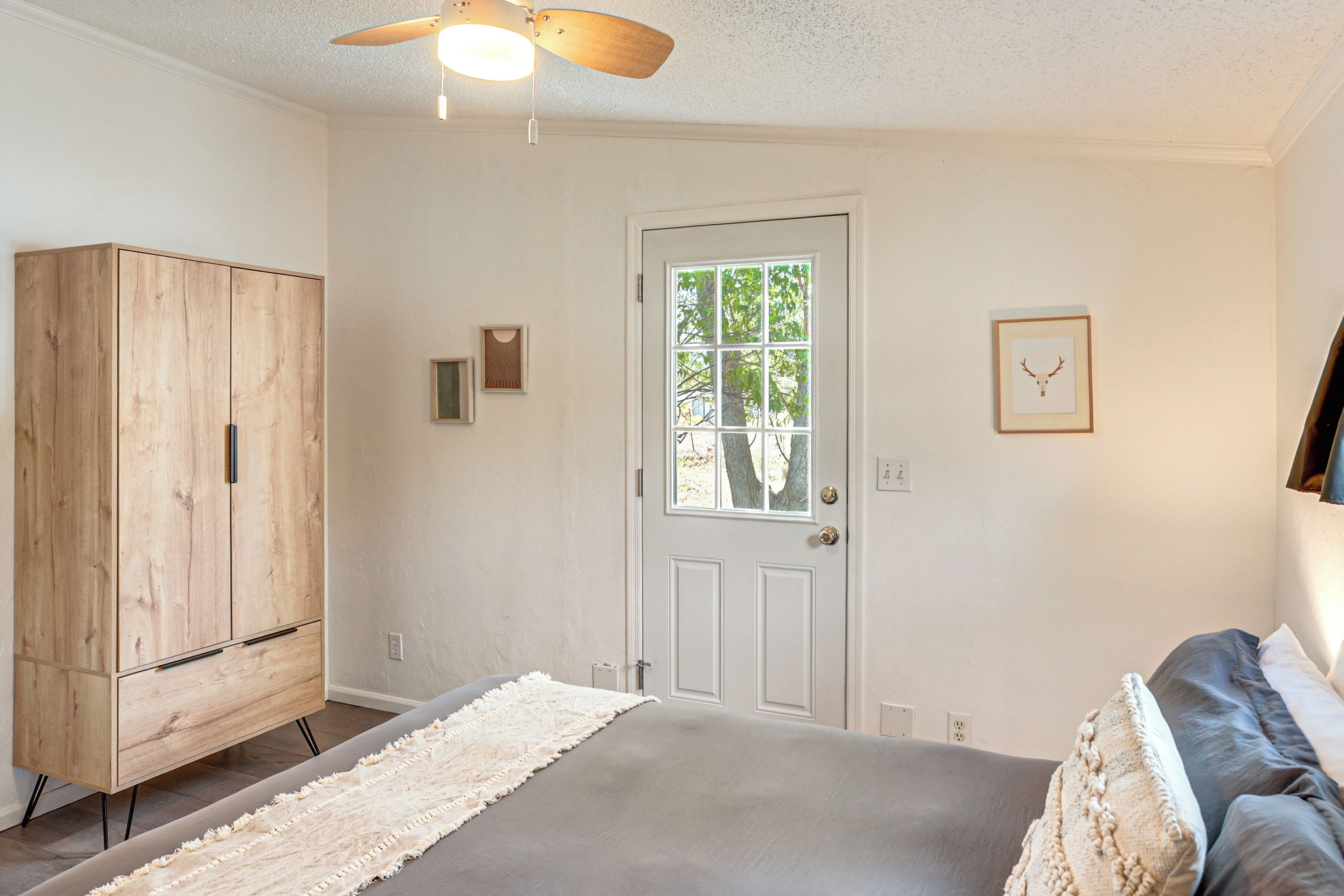 Un dormitorio con cama, armario, puerta y ventana.