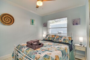 A bedroom with a bed, a bedside table, a lamp, and a ceiling fan. - Walk to Gulf & Beaches! Indian Rocks Beach Haven (Indian Rocks Beach)