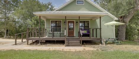 A small, single-story house with a porch, a small window, and a door.