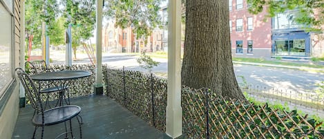 An outdoor seating area with a covered patio, a table, and chairs.