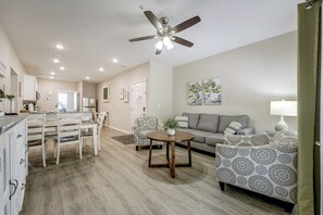 A modern living room with a sofa, armchairs, a coffee table, and a ceiling fan. - Condo Near Branson Strip: Close to It All! (Branson)