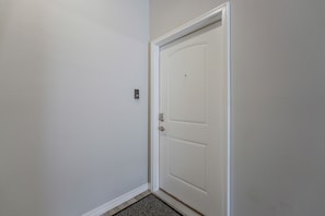 A white door with a doorknob and a small electronic lock on the wall beside it. - Condo Near Branson Strip: Close to It All! (Branson)