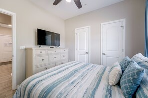 A bedroom with a bed, dresser, television, and two doors. - Condo Near Branson Strip: Close to It All! (Branson)