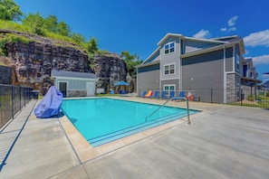 A swimming pool with a lifeguard stand, lounge chairs, and a covered area. - Condo Near Branson Strip: Close to It All! (Branson)