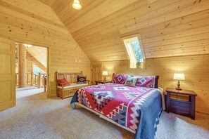 A log cabin bedroom with a bed, nightstands, a bench, and a window. - Ski, Hike & Explore! Spacious Conway Cabin w/ Deck (Albany)