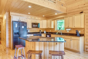 A wooden cabin kitchen with a central island, wooden cabinets, a refrigerator, a microwave, and a stove. - Ski, Hike & Explore! Spacious Conway Cabin w/ Deck (Albany)