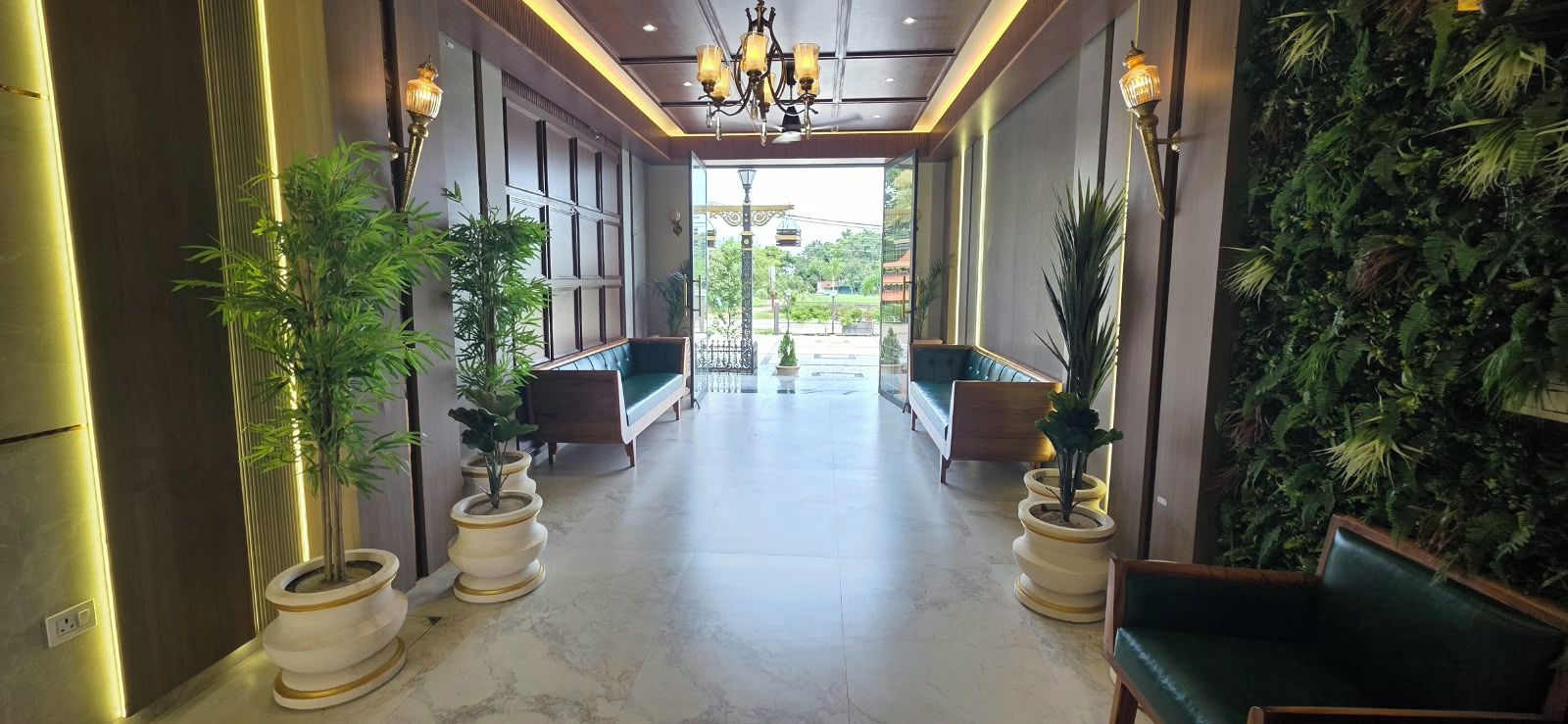A hallway with seating areas, potted plants, and a view of the outdoors.