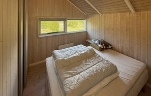 A single bed in a room with wooden walls and a window. - Beautiful home in Rødby with sauna (Rødby)
