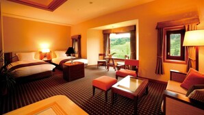 Une chambre d’hôtel avec deux lits, une table à manger, un canapé et une vue sur l’extérieur.