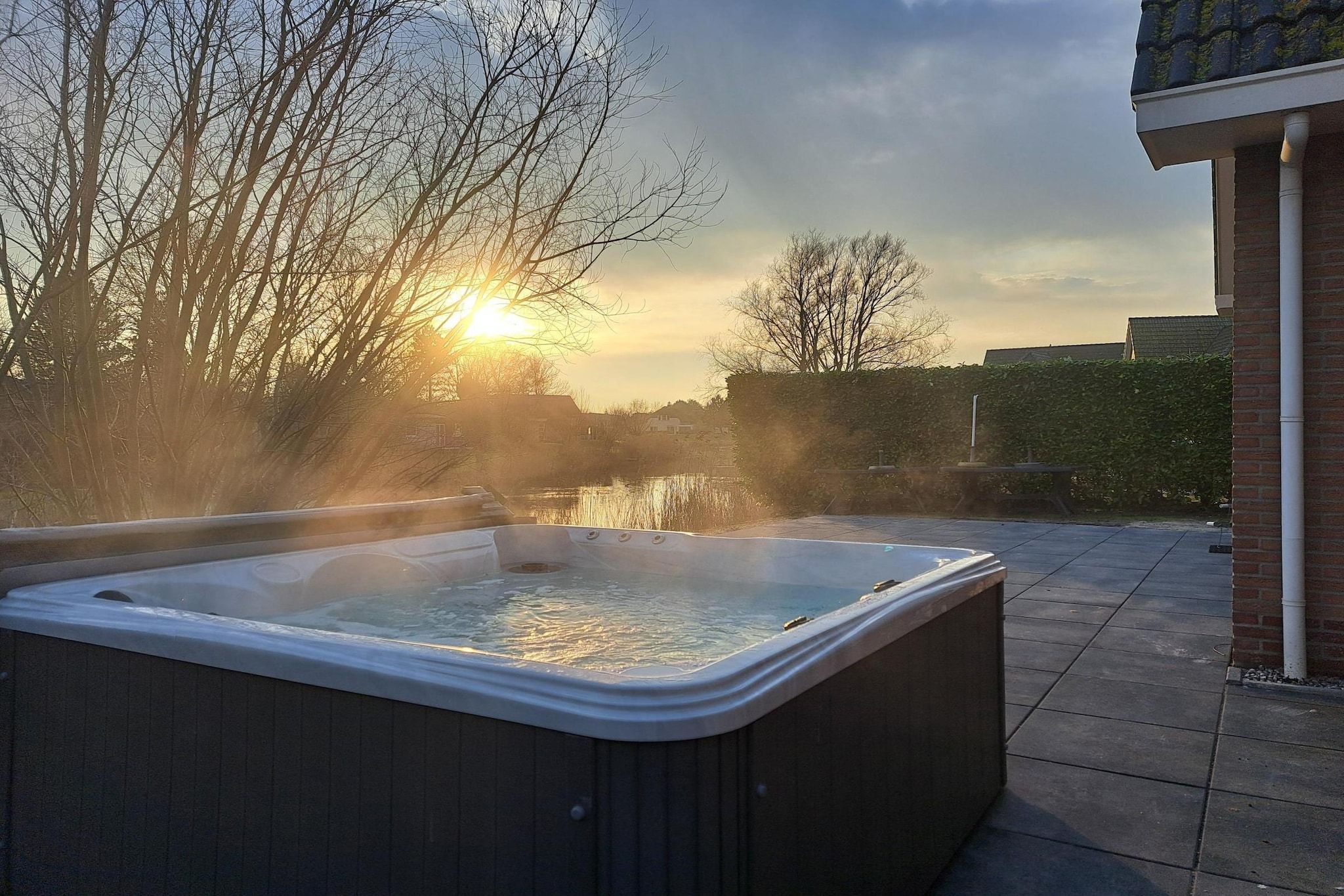 A hot tub outdoors with a sunset in the background.