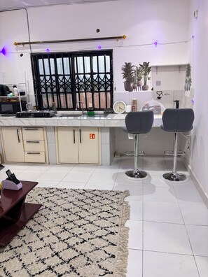 Una cocina moderna con barra, un reloj y un letrero de café en la pared.