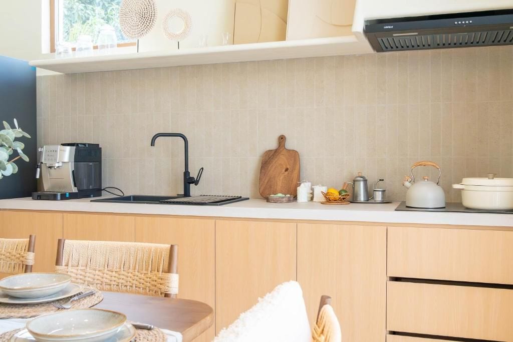 Eine moderne Küche mit integriertem Kaffeeautomaten, Wasserkocher und Toaster auf der Arbeitsfläche.