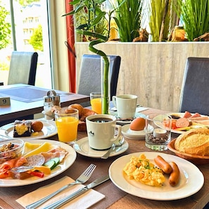 Un bufé de desayuno con diversos alimentos y bebidas.