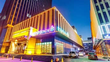 A modern building with illuminated signage, large windows, and a prominent entrance.