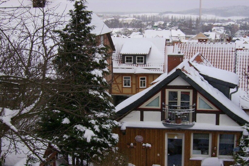 Un immeuble résidentiel doté d’un toit en pente, d’un balcon et d’une porte bien visible.