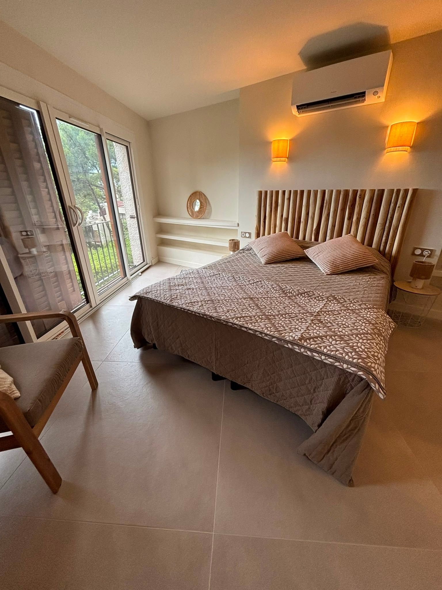 Een slaapkamer met een bed, een raam en een airconditioning.