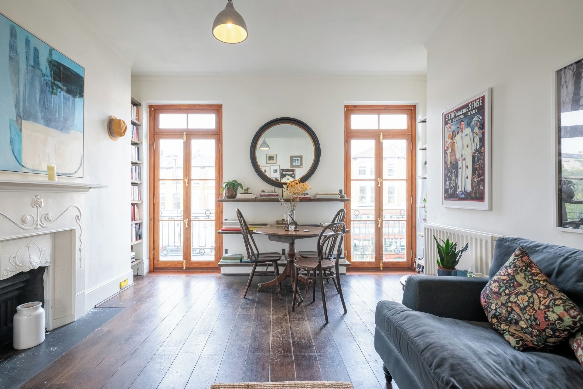 A living room with a fireplace, a dining area with a round table, and a sofa with a patterned cushion.