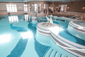 Una piscina interior con varios niveles y una fuente central.